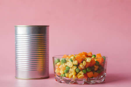 Open can of fruit cocktail pink backgroundの写真素材