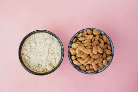 almond powder and almond in a bowl on pinkの写真素材