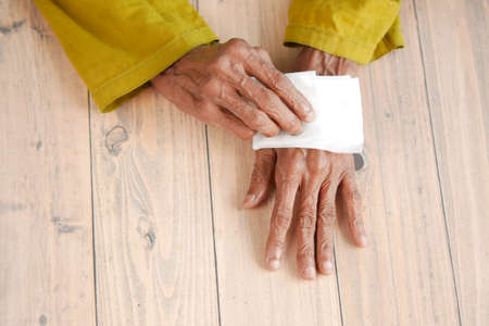senior women disinfecting his hands with a wet wipe.の写真素材