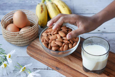 hand pick almond nut with egg and milk on tableの写真素材