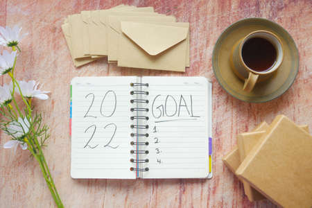 2022 new year goals on notepad with tea and box on tableの写真素材