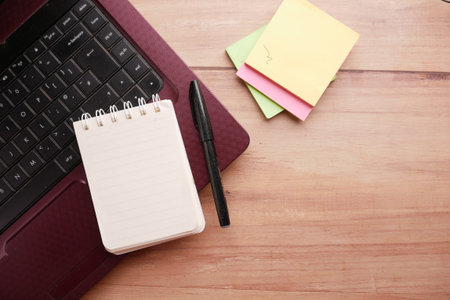 high angle view of open notepad and laptop on tableの写真素材