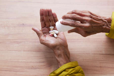 close up of pills and capsule on senior womens handの写真素材