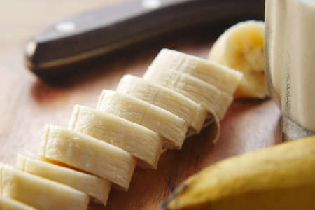 close up of slice of banana glass of milk on tableの写真素材