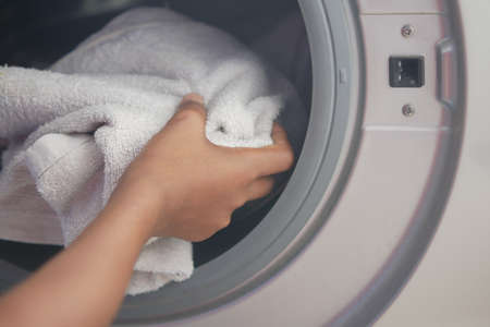 putting towel and cloths in a washing machine.の写真素材