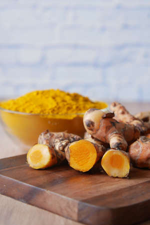 turmeric root and a power in bowl on table ,の写真素材