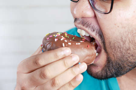 close up of young man eating donut ,の写真素材