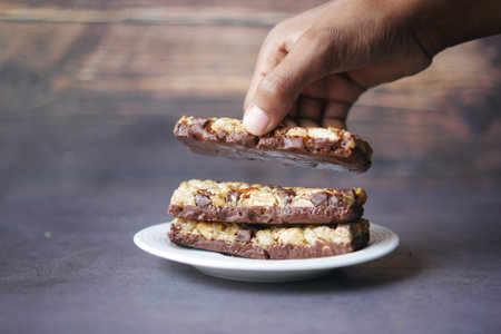 hand pick a Almond , Raisin and oat protein bars on tableの写真素材