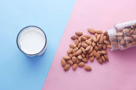 top view of almond nut and milk on color backgroundの写真素材