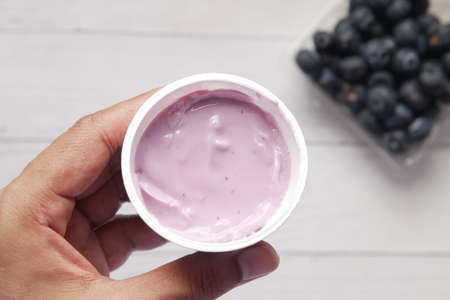 hand hold fresh yogurt in a plastic containerの写真素材