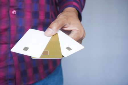 Man in casual dress showing many credit cardの写真素材