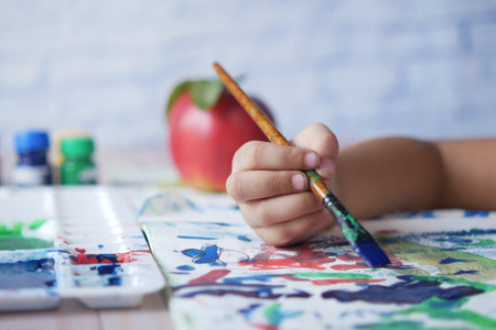 child girl drawing on paper with art brushの写真素材