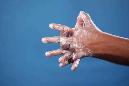 child boxy washing hands with soap on blue backgroundの写真素材