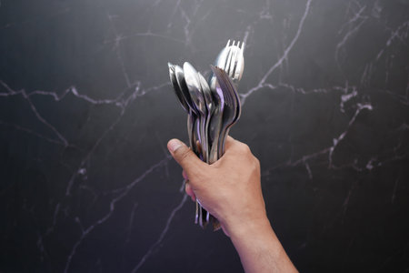 hand hold many sliver spoon top viewの写真素材