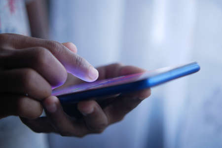 child hand pointing finger on smart phone screen.の写真素材