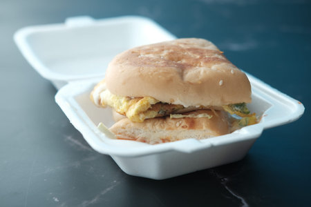 beef burger and french fries in a takeaway paper box on table