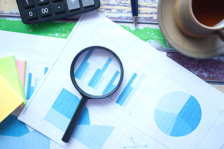 financial data and magnifying glass on blue .の写真素材