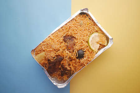 mutton biryani meal in a plastic take away box on color backgroundの写真素材
