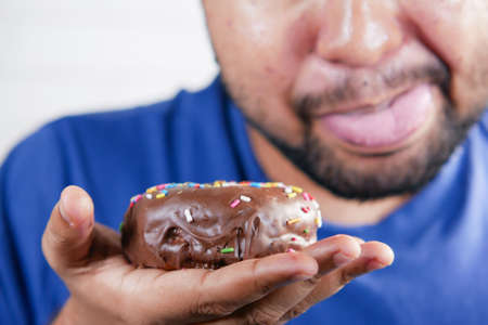 young man eating donut , selective focusの写真素材