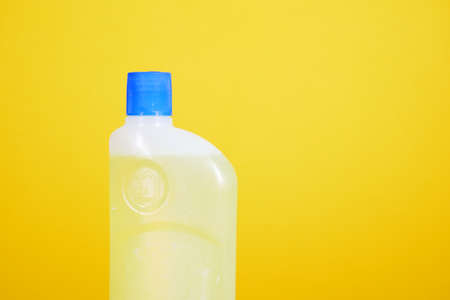 floor cleaning disinfect bottle against yellow backgroundの写真素材