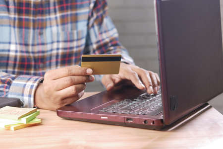 man hands holding credit card and using laptop shopping onlineの写真素材