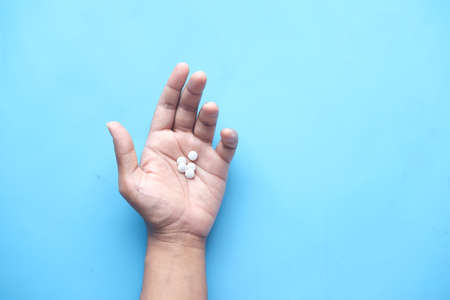 mans hand with medicine spilled out of the pill containerの写真素材