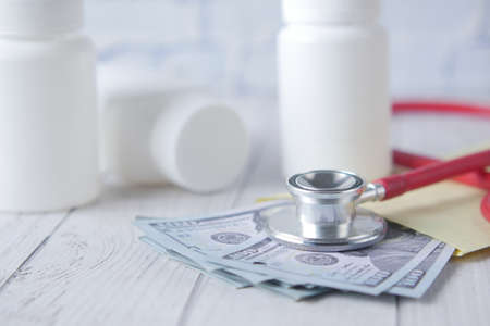 Healthcare cost concept with us dollar , container and pills on tableの写真素材