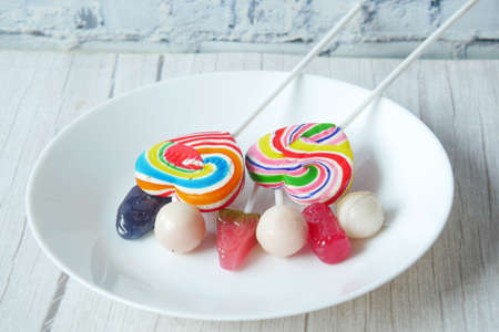 colorful lollipop wrapper on a plate on tableの写真素材