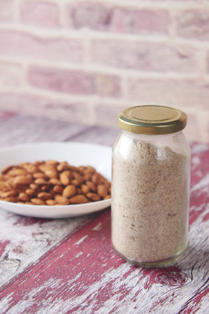 almond powder and almond in a jar on table,の写真素材