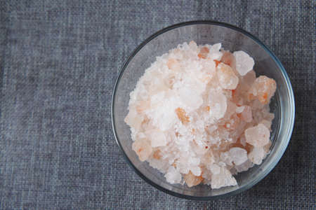 close up of pink rock salt in a bowl on tableの写真素材
