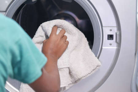 putting towel and cloths in a washing machine.の写真素材