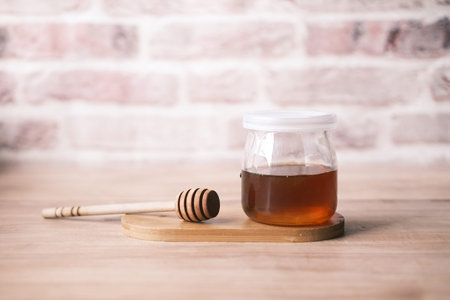 fresh honey in a glass jar on table with copy spaceの写真素材