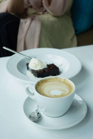 a cup of late coffee with flower shape design on top at cafeの写真素材