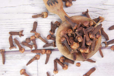 cloves on a spoon on table close upの写真素材