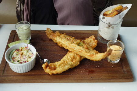 Fish fillet, lemon , chips and potato mash on tableの写真素材
