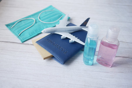 protective mask, airplane and blue color passport on tableの写真素材