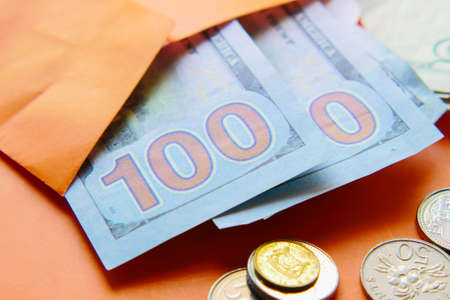Close up of cash and coins in a envelope on tableの写真素材