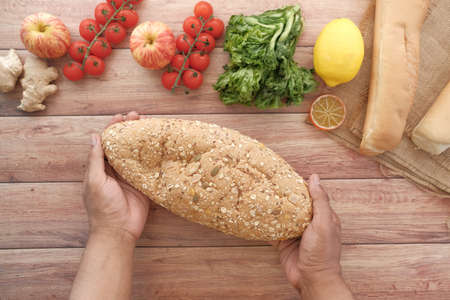 slice of whole meal bread and fresh vegetables on tableの写真素材