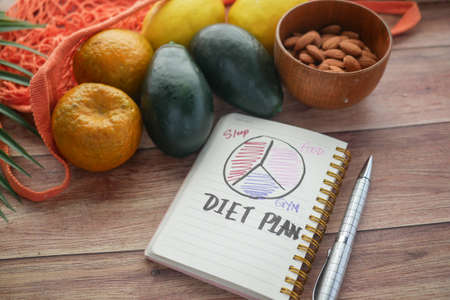 Diet plan with almond nuts and fresh fruit on tableの写真素材