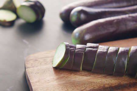 cutting eggplant on a chopping boardの写真素材