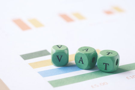 Wooden block with a VAT word on financial dataの写真素材