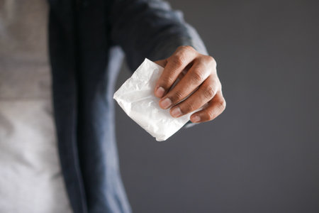 drug addiction concept with hand holding heroine packet on black backgrundの写真素材
