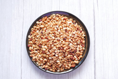 Processed pea nuts in a bowl on table top down .の写真素材