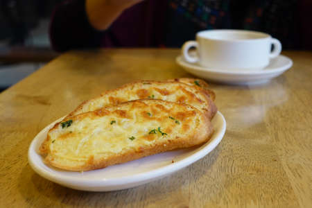 hand pick a garlic bread on a plateの写真素材