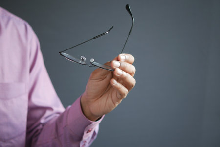 Close up of man hand holding old eyeglassの写真素材