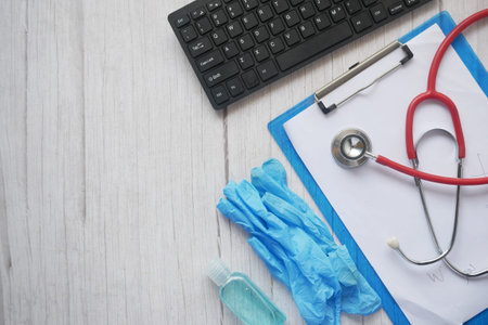 White sheet paper with silver pen, stethoscope and pills on table.