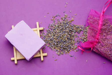 Homemade natural soap bar and lavender flower on purple backgroundの写真素材