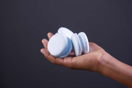 hand hold macaroon against gray backgroundの写真素材