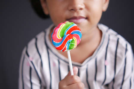 hand hold rainbow heart shape lollipopの写真素材