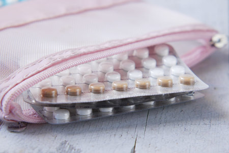 birth control pills on wooden background, close up